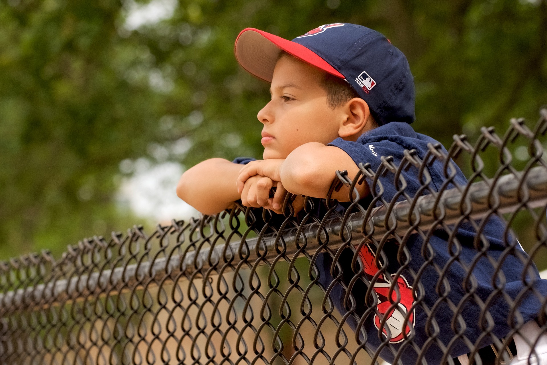 kid hanging onto a fence