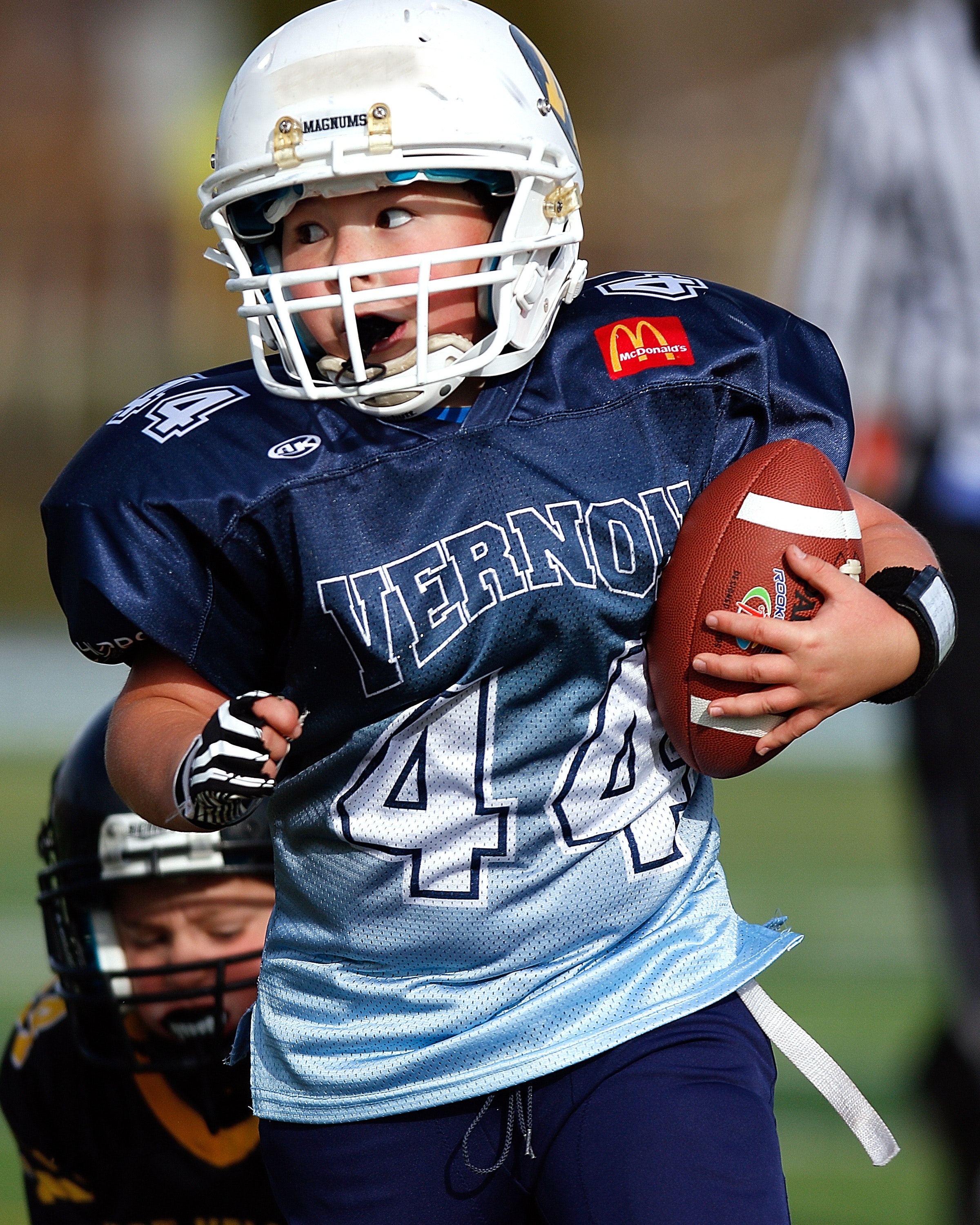 americal fottball kid athlete holding onto football