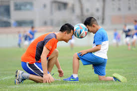 kid and adult playing soccer together